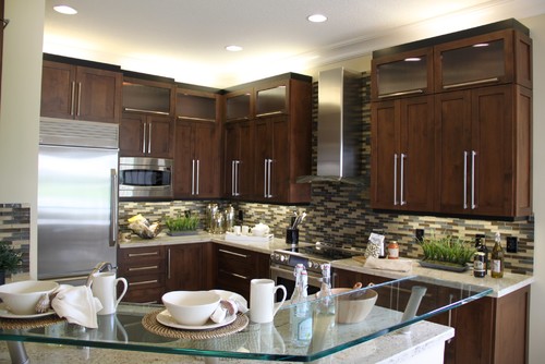 River White Countertop and River White Island Top, Perforated Glass Raised Breakfast Bar, Alder Woods Cabinets with Cappuccino Stain, Alder Woods Glass Door Wall Cabinets, Matchstick Glass Stone Blend Tiles, Kitchen Recess Lights and Stainless Steel Hood and Stainless Steel Appliances